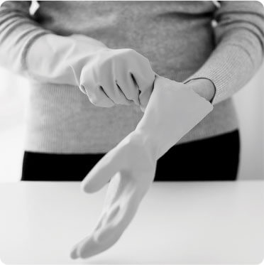 photo of a female cleaner putting on gloves