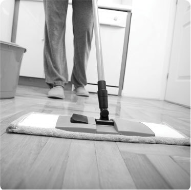 photo of a cleaner cleaning a wooden floor with a mop